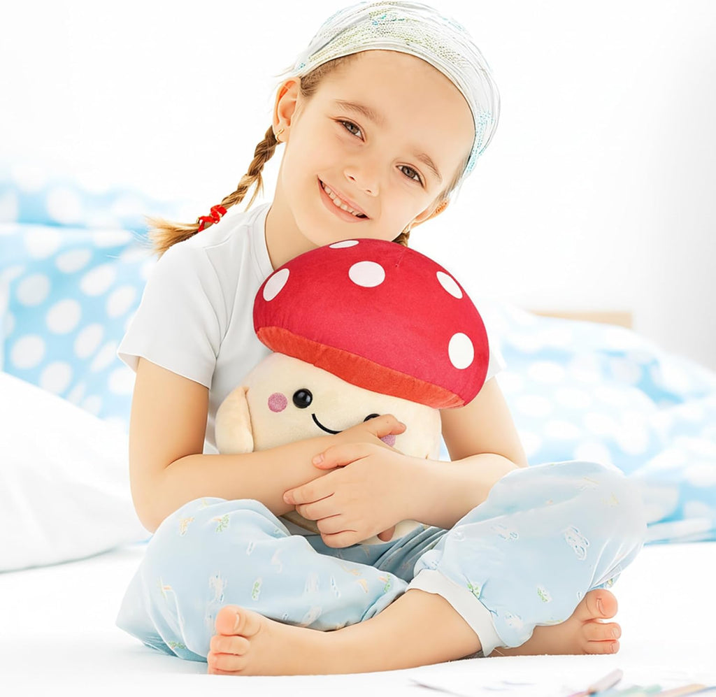 Child holding a red mushroom-shaped pillow with a smiley face on a white background
