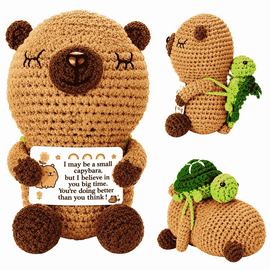 Crocheted teddy bear with a message card and a small green creature on a white background