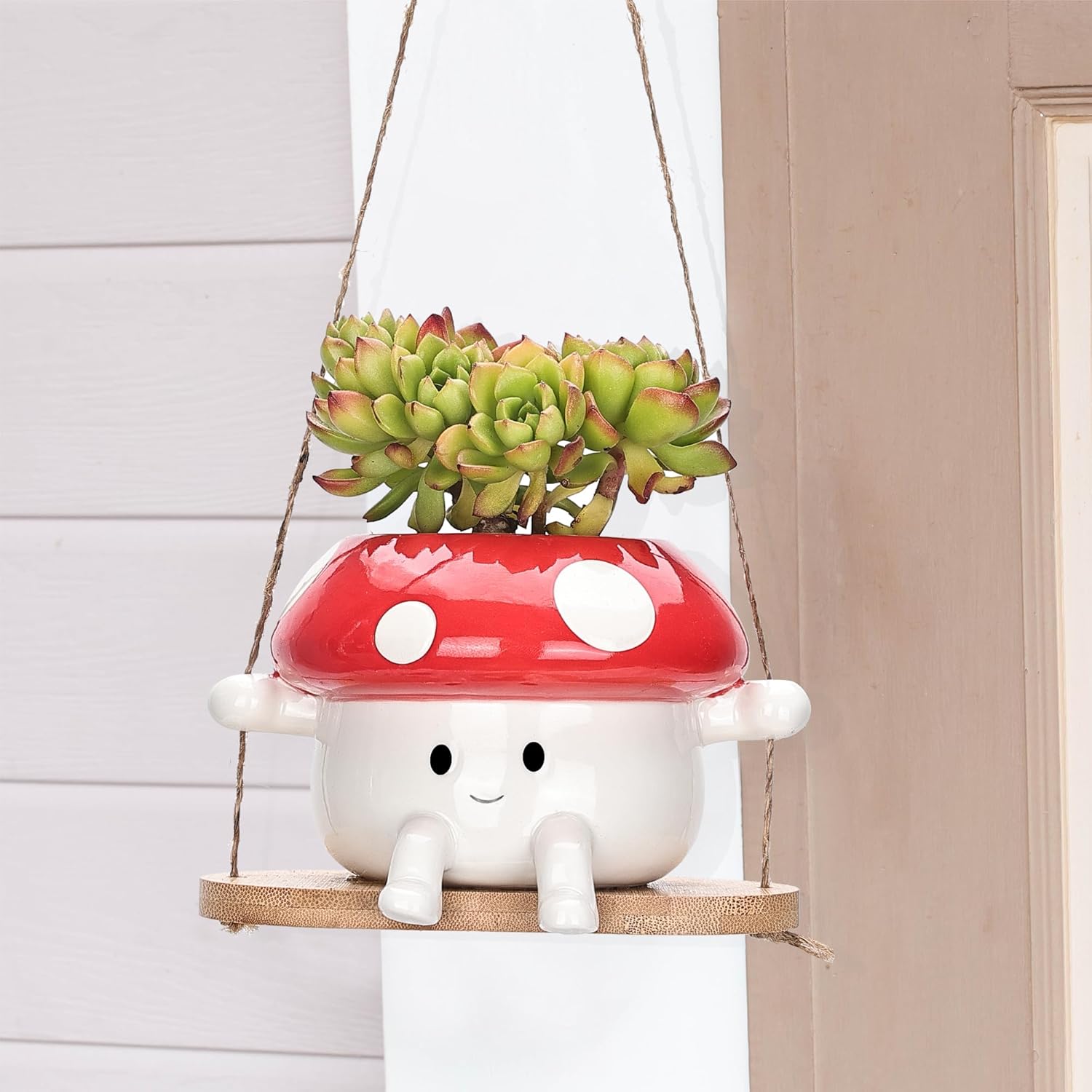 Mushroom-shaped hanging planter with succulents on a neutral background