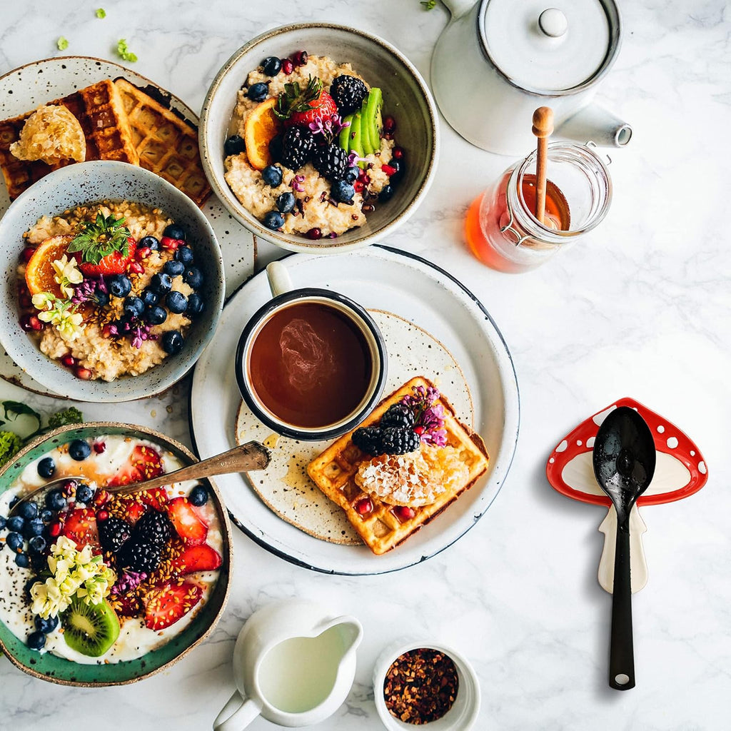Breakfast spread with bowls of oatmeal, waffles, and a cup of coffee on a marble surface.