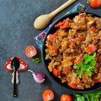 Stir-fried vegetables with a wooden spoon on a dark surface